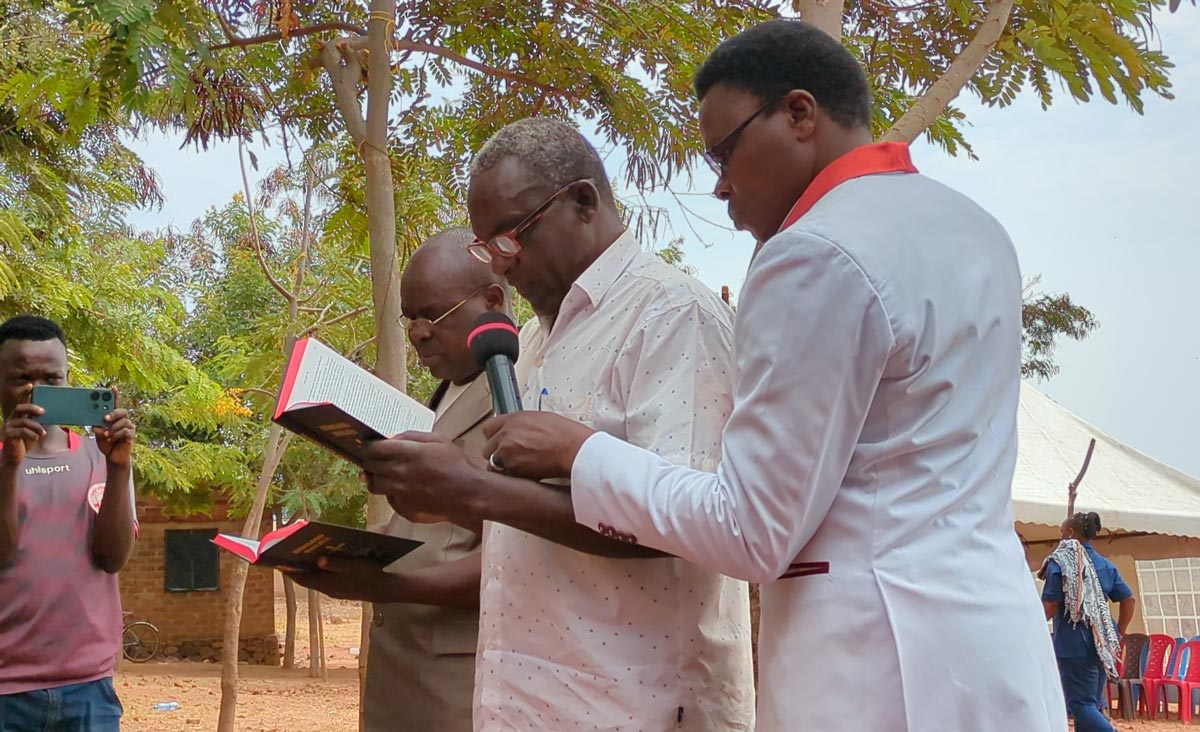 Reading the Jita New Testament at the dedication.